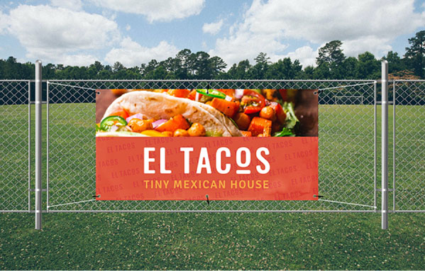 A wooden fence displaying a sign that reads El Tacos, indicating a taco stand or restaurant nearby.