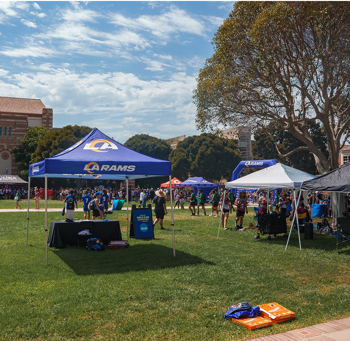 A diverse group of people seated together under a large tent, engaged in conversation and enjoying their time.