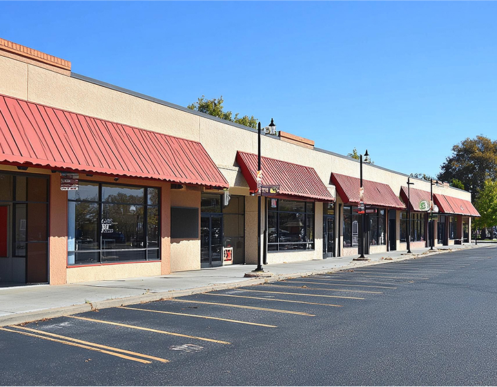 A parking lot featuring a prominent red awning overhead, providing shade and shelter for vehicles parked below.